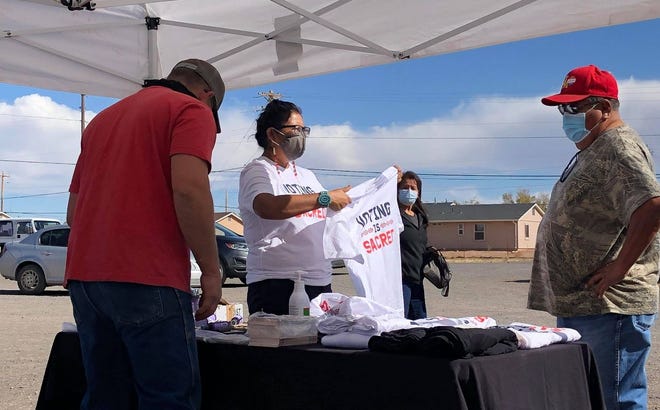 ​Volunteers with the nonprofit organization Diné C.A.R.E. (Citizens Against Ruining Our Environment) talk with Navajo Nation voters at the Dilkon Chapter House in Dilkon, Arizona, on Election Day in 2020.