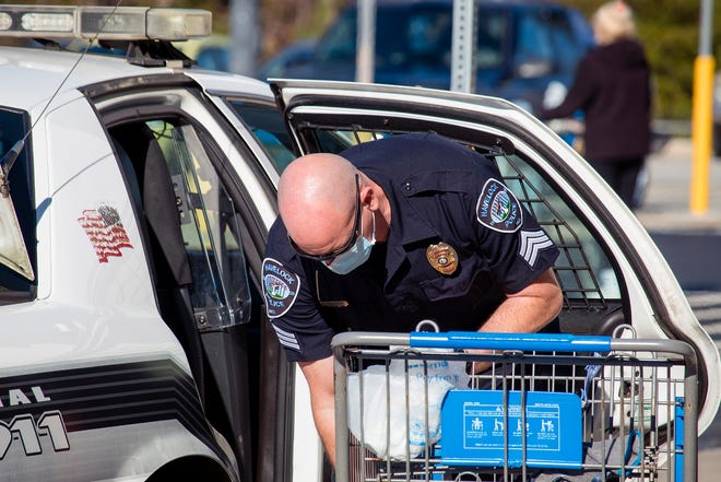 Sgt. Josh Casassa from the Havelock Police Department loads a cruiser with food donations during 'Pack-a-Patrol Car' – a joint event between the HPD and Walmart.