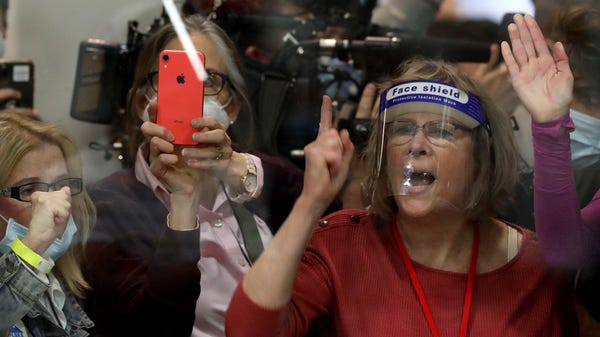 People outside a ballot counting area bang on the 