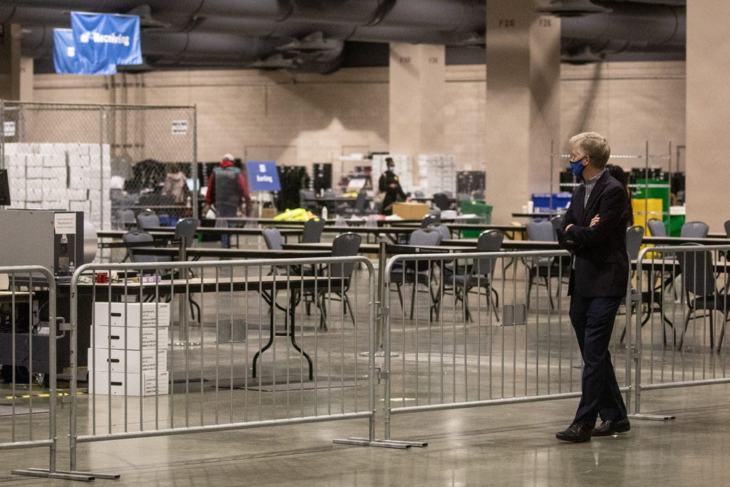 A man watches from the observers' area as election workers count ballots at the Philadelphia Convention Center on Nov. 6, 2020.