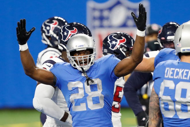 Lions running back Adrian Peterson raises his arms after a play during the first quarter against the Houston Texans at Ford Field on Thursday, Nov. 26, 2020.