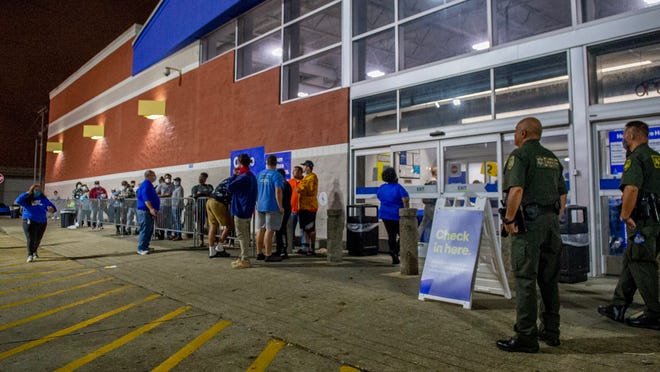 Long lines form in front of businesses in the early hours of Friday to get some of the best deals of the year Friday, Nov. 27, 2020.