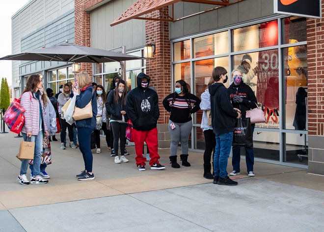 Black Friday shoppers wait in line to enter a store that opened at 6am at Tanger Outlets in Southaven, Miss., on Friday, November 927 2020.