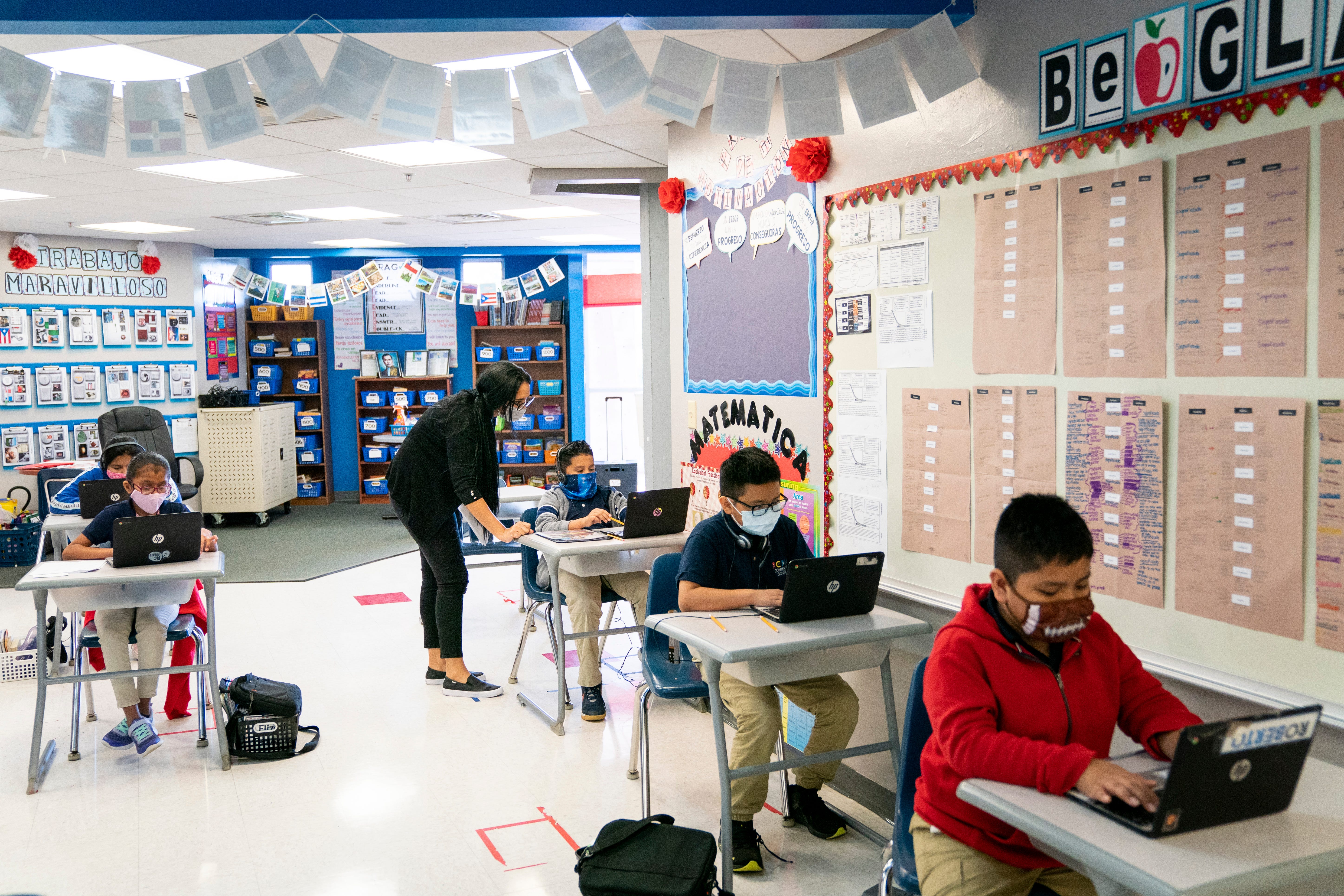 Fifth-grade teacher Uyslamis Echeverria-Ramos helps a student at RCMA Immokalee Community School in Immokalee during an exam in November. Nearly all the students returned to in-person learning for the school year, which Principal Zulaika Quintero says helps the school to keep tabs on students' educational progress and emotional states.