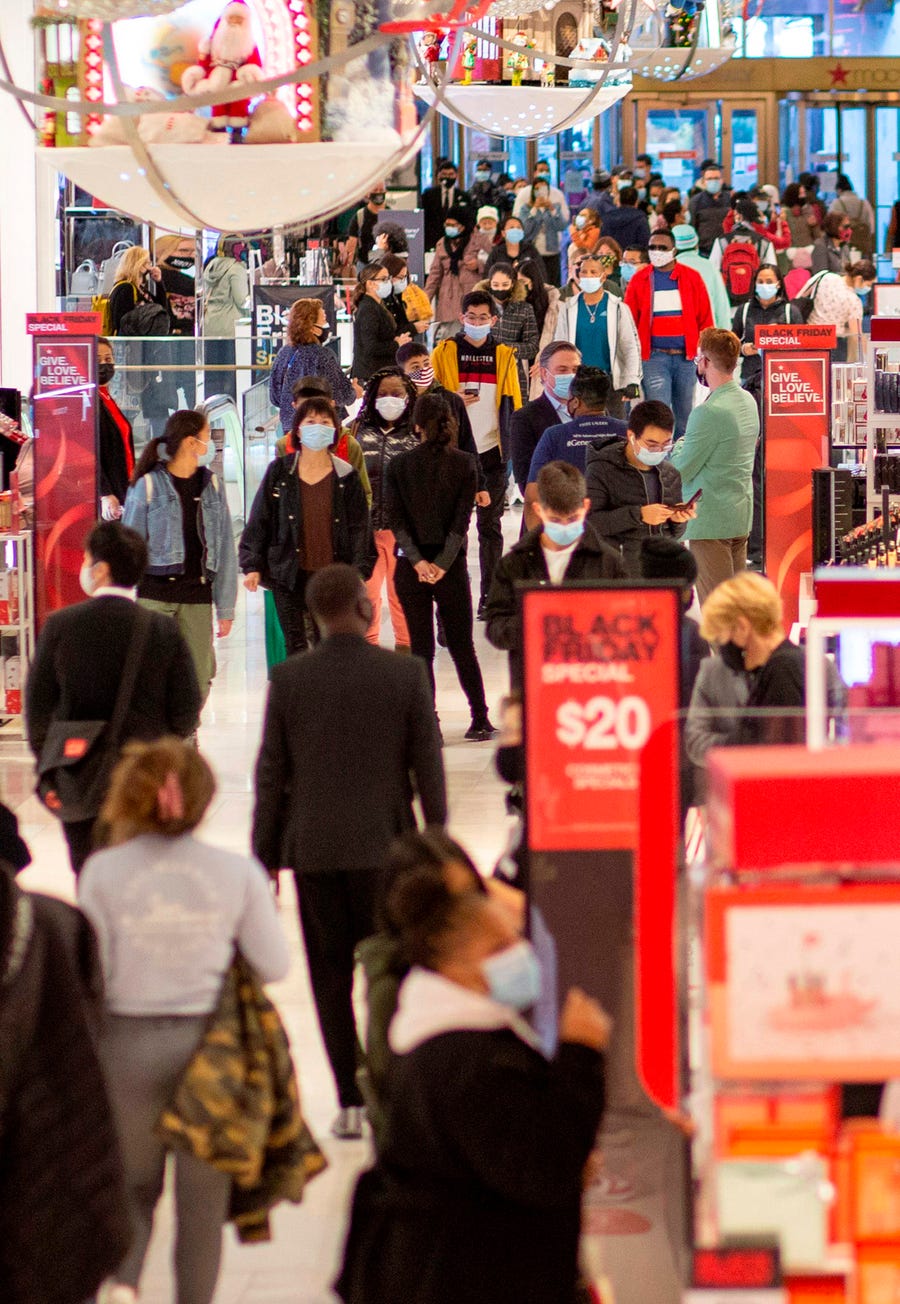 Customers shop at Macys department store in New York on Black Friday, November 27, 2020. - The coronavirus is clouding "Black Friday" much as it has overshadowed 2020 in general, but some leading experts still expect strong overall sales even as shopping patterns are altered.