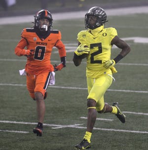 Oregon's Devon Williams (2) outruns Oregon State's Akili Arnold for a second-quarter touchdown reception during the Beavers' 41-38 win over the Ducks last year in a foggy Reser Stadium in Corvallis.