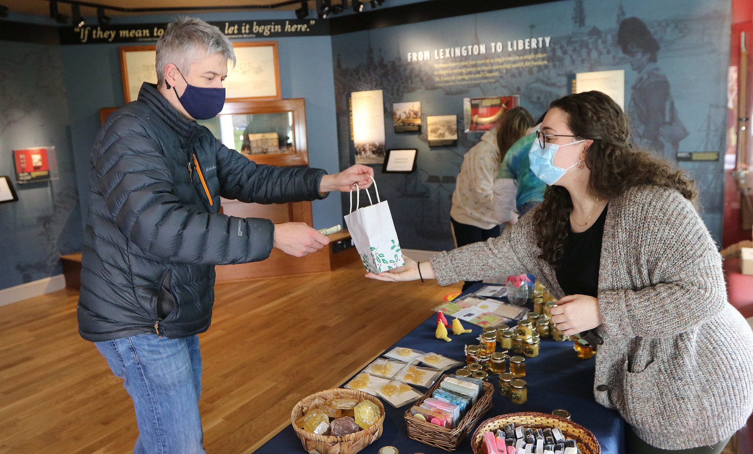 Andy Taggart, of Lexington, bought some items from Lexington High School senior Sophie Gregoretti, 17, at the Lexington Bee Company table in the Lexington Visitors Center, Nov. 28.