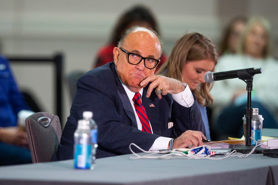 President Donald Trump's attorney Rudy Giuliani (right) listens to presenters at a public meeting where supporters of President Trump disputed his defeat in the 2020 election, citing election fraud and other concerns, at the Hyatt Regency Hotel in Phoenix, Arizona on Nov. 30, 2020.