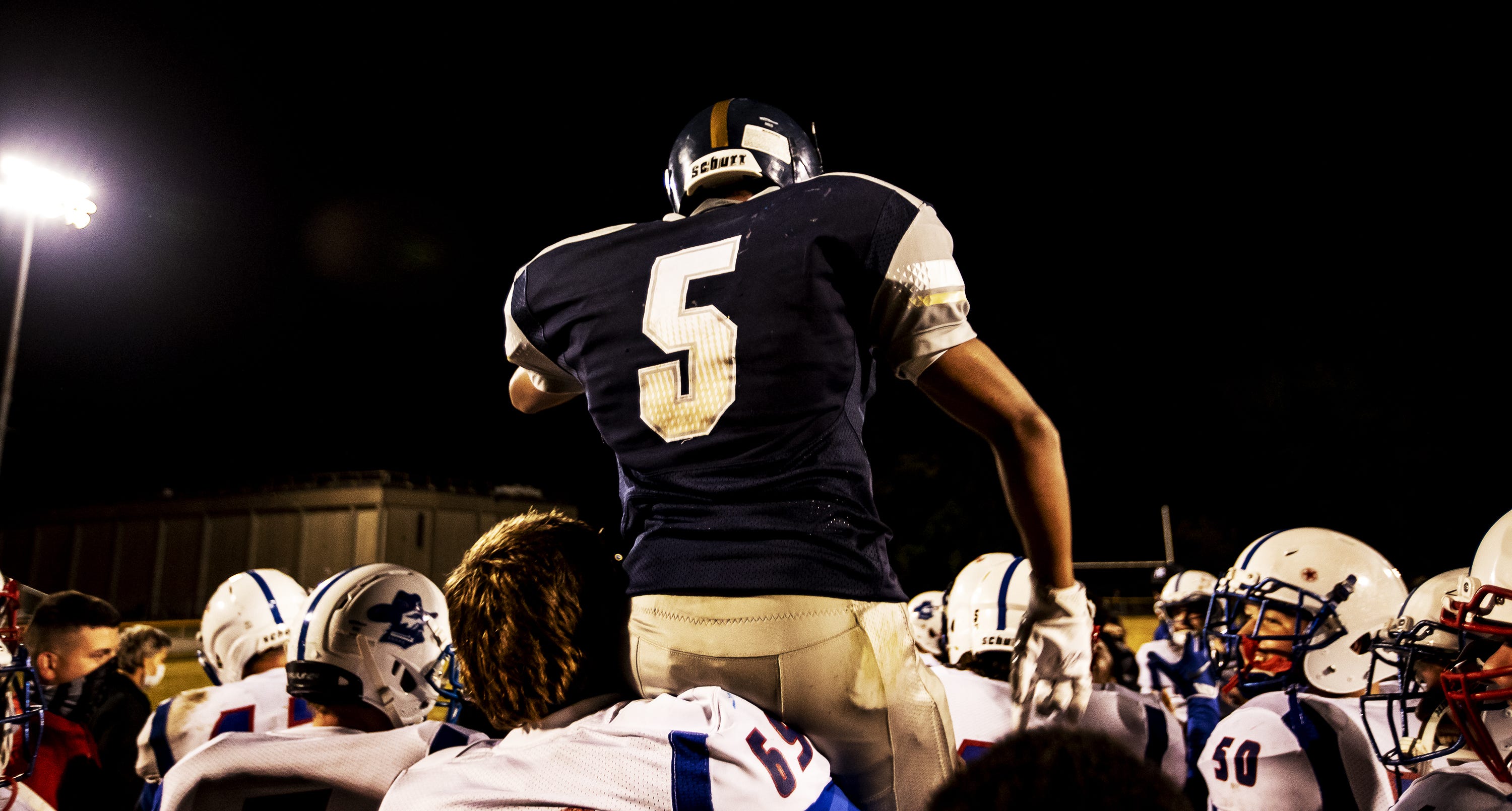 Jackson County freshman James Gibson carries Academy @ Shawnee senior Robert Harper on his shoulders as players from both teams celebrate together after the game on Oct. 22, 2020.