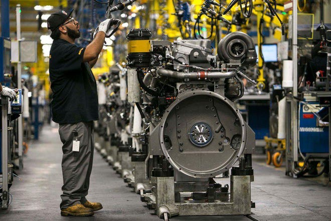 An employee works on an engine at Caterpillar's engine manufacturing plant in Seguin last year. A new report from the Federal Reserve Bank of Dallas indicates manufacturing activity in Texas has been slowing amid rising cases of the coronavirus this fall.