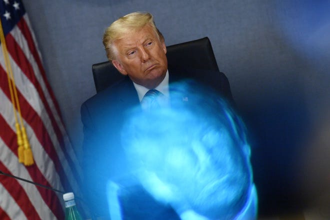 A reflection of President Donald Trump from a monitor at a meeting in August 2020.