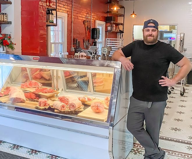Cameron Matthews, owner of Butcher's Son butcher shop, stands next to the display case at his new Market Street business.
