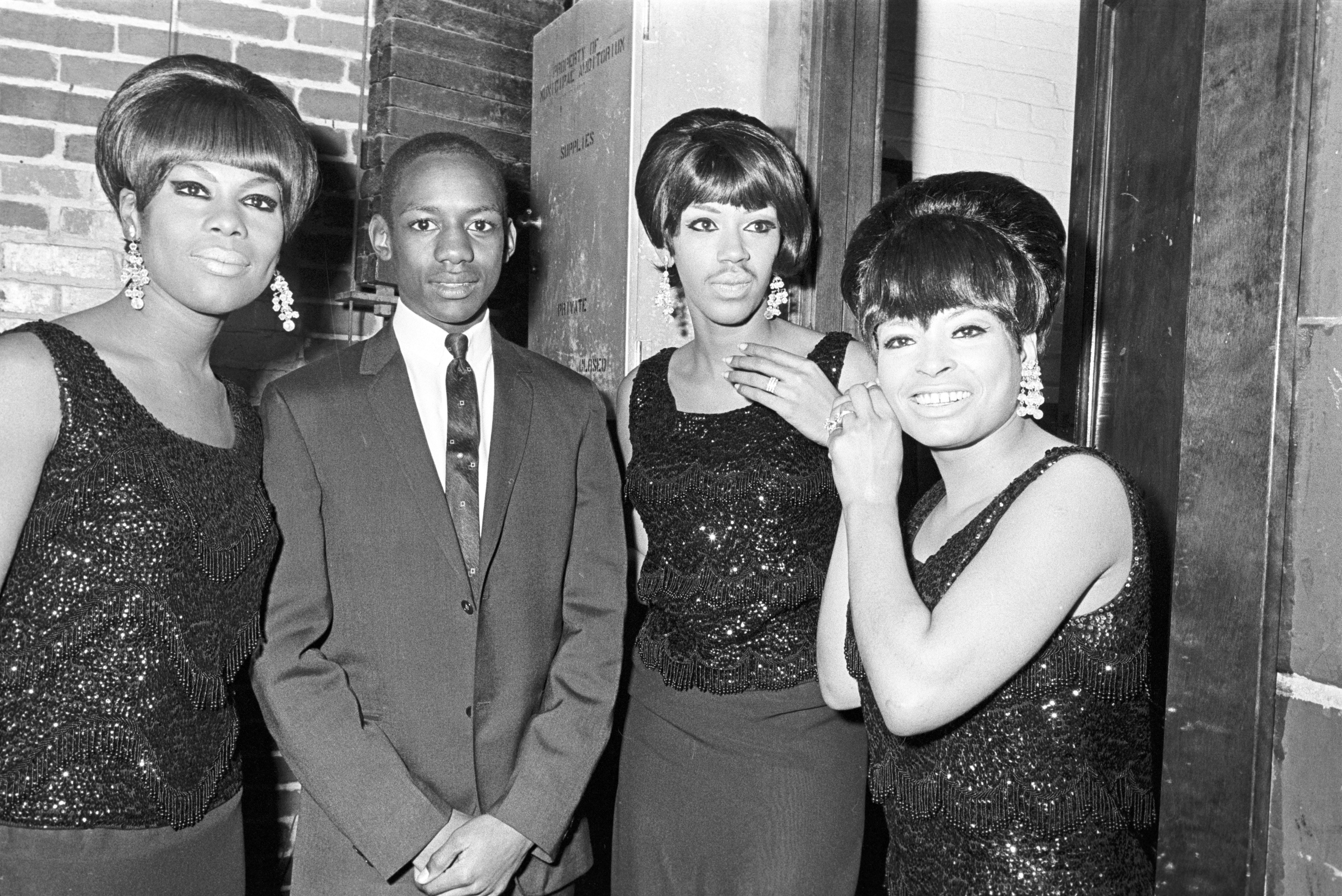 A young man stands with the Marvelettes at the Montgomery City Auditorium during a performance of the Otis Redding Show