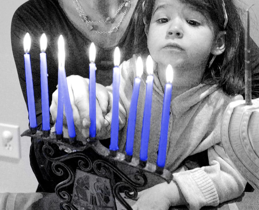 Jennifer Rivlin Roberts helps her daughter Isabel, 2, place the center candle into their family menorah, Friday, Nov. 9, 2007 in Atlanta.