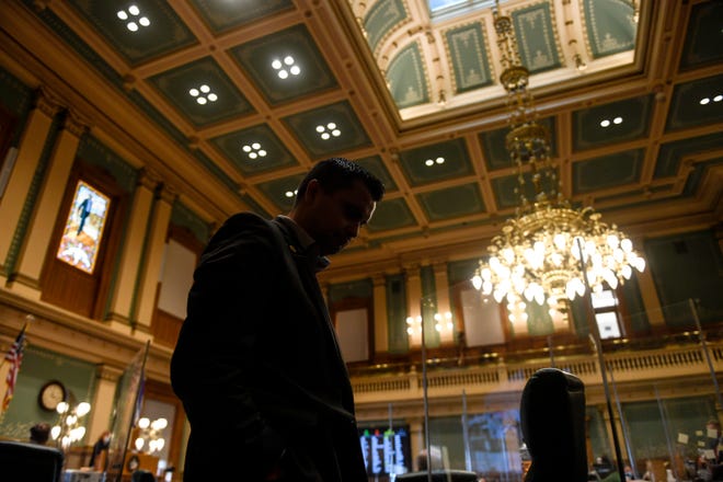 Republican Rep. Dave Williams hangs his head as he walks the sidelines of the House floor, while opting not to wear a face mask during a special legislative session at the Colorado State Capitol on Wednesday, Dec. 2, 2020, Denver. Colorado lawmakers have passed several bills offering assistance to restaurants and food pantries struggling to keep their doors open during the coronavirus pandemic. The special session that was called by Gov. Jared Polis ended on Wednesday.