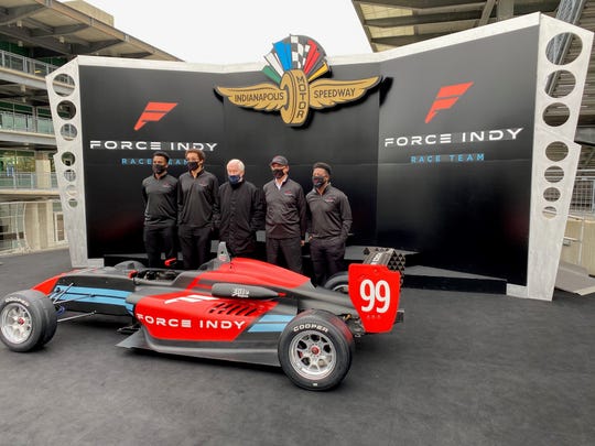 Force Indy crewmen Nadeem Ali (far left), Stewart Kelly (second from left) and Derek Morris (far right) pose with Roger Penske (center) and Force Indy team principal Rod Reid (second from right) at the Indianapolis Motor Speedway Thursday.