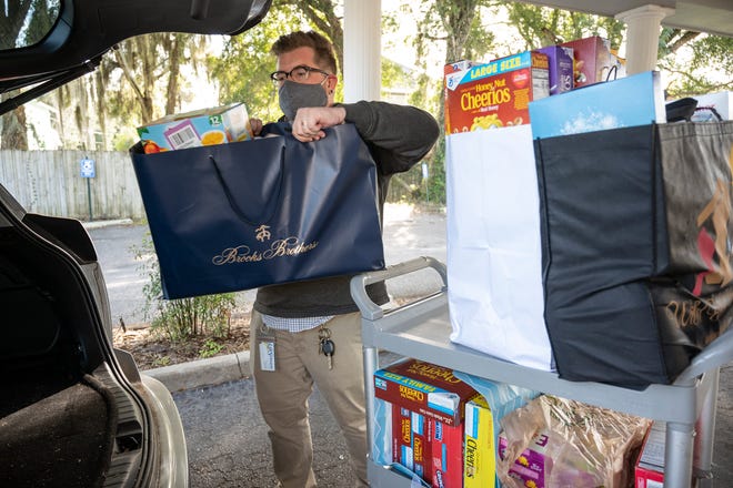 Ash Wallace of The Open Door ministry loads food donations into his car to be transported back to their facility. [Cindy Peterson/Correspondent]