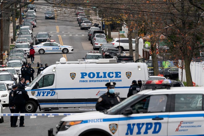 Police vehicles are parked near the scene of a shooting in The Bronx on Friday. A suspect in the shooting of a Massachusetts state trooper was killed in a shootout with U.S. marshals in New York City.