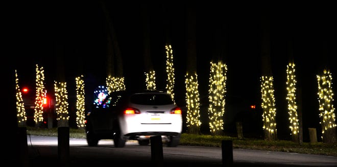 Motorists pass displays of holiday lights Dec. 5, 2020, at Presque Isle State Park during the first Presque Isle Lights event.