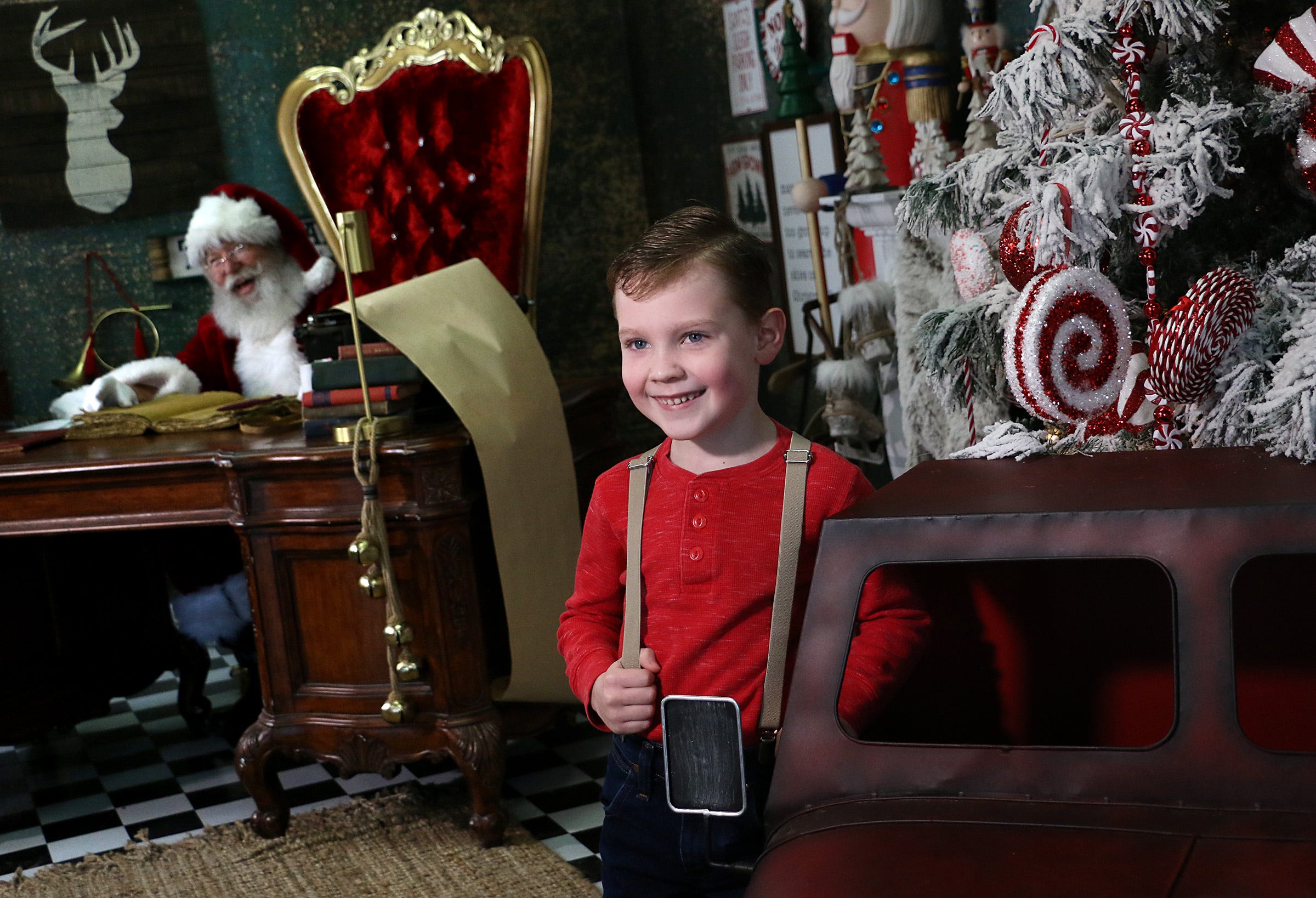 6 year old William Hopper poses for a portrait near Santa while visiting the Santa Experience with GMH Photography in Reno on Dec. 5, 2020.