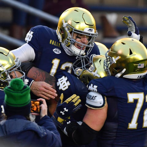 Notre Dame quarterback Ian Book celebrates after r