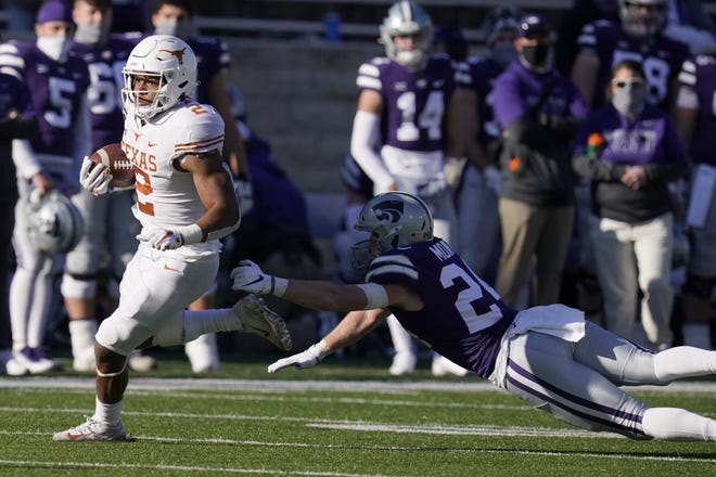 Texas running back Roschon Johnson (2) gets past Kansas State defensive back Brock Monty (24) during the second half of an NCAA college football game in Manhattan, Kan., Saturday, Dec. 5, 2020.  (AP Photo/Orlin Wagner)