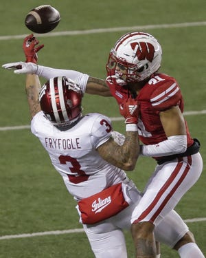 Wisconsin's Caesar Williams (21) breaks up a pass intended for Indiana's Ty Fryfogle (3) on Saturday, Dec. 5, 2020, at Camp Randall Stadium in Madison, Wis. Indiana won the game, 14-6.