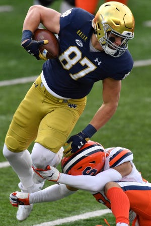 Dec 5, 2020; South Bend, Indiana, USA; Notre Dame Fighting Irish tight end Michael Mayer (87) is tackled by Syracuse Orange safety Aman Greenwood (26) in the first quarter at Notre Dame Stadium.
