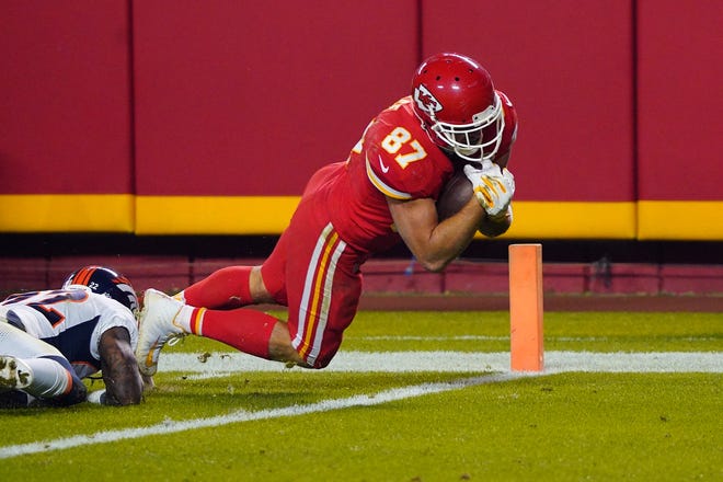 Kansas City Chiefs tight end Travis Kelce (87) scores a touchdown ahead of Denver Broncos strong safety Kareem Jackson (22) during the second half on Sunday night at Arrowhead Stadium in Kansas City.