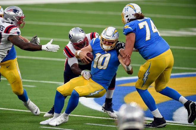 Chargers quarterback Justin Herbert (10) is sacked by Patriots defensive tackle Adam Butler during the second half of Sunday's game. Overall, Herbert completed only 26 of his career-high 53 attempts for just 209 yards and had two interceptions.
