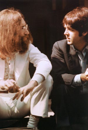 John Lennon, left, and Paul McCartney talk during the photo session for the cover of the "Abbey Road" album in 1969.