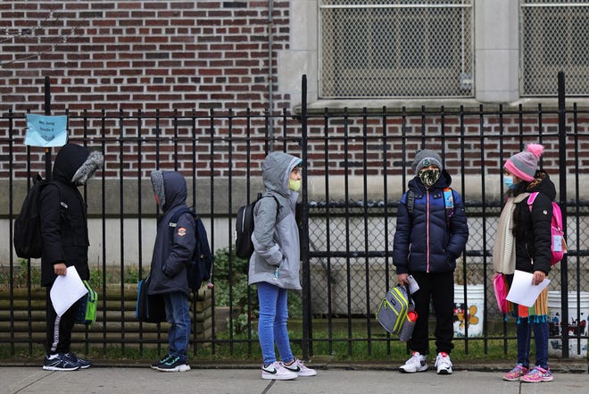 Children returning to school line up before entering P.S. 179 Kensington on December 7 in New York City. The city's public schools are open for some in-person learning, but the teachers' union is concerned about the rising rate of positive COVID-19 test results.