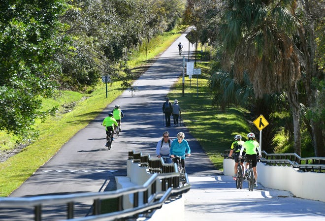 Cyclists and pedestrians use the recently completed Laurel Road Legacy Trail overpass last year.
