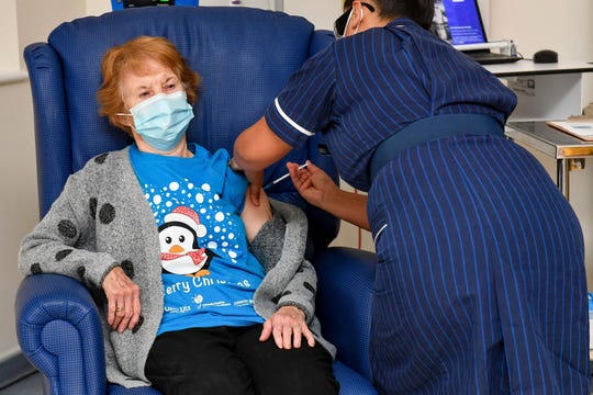 Margaret Keenan, 90, becomes the first patient in the world to receive the Pfizer-BioNTech COVID-19 vaccine. The shot was administered by nurse May Parsons, right, at University Hospital, Coventry, England, on Dec. 8, 2020.