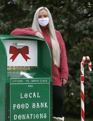Sarah Bailey stands next to a donation box near her familyÕs elaborate Christmas display on Wednesday, Dec. 9, 2020 in Twinsburg. Bailey, a huge Taylor Swift fan, was surprised when the recording artist messaged her after seeing the display on Social media and making a donation to the food bank.  [Mike Cardew/Beacon Journal]