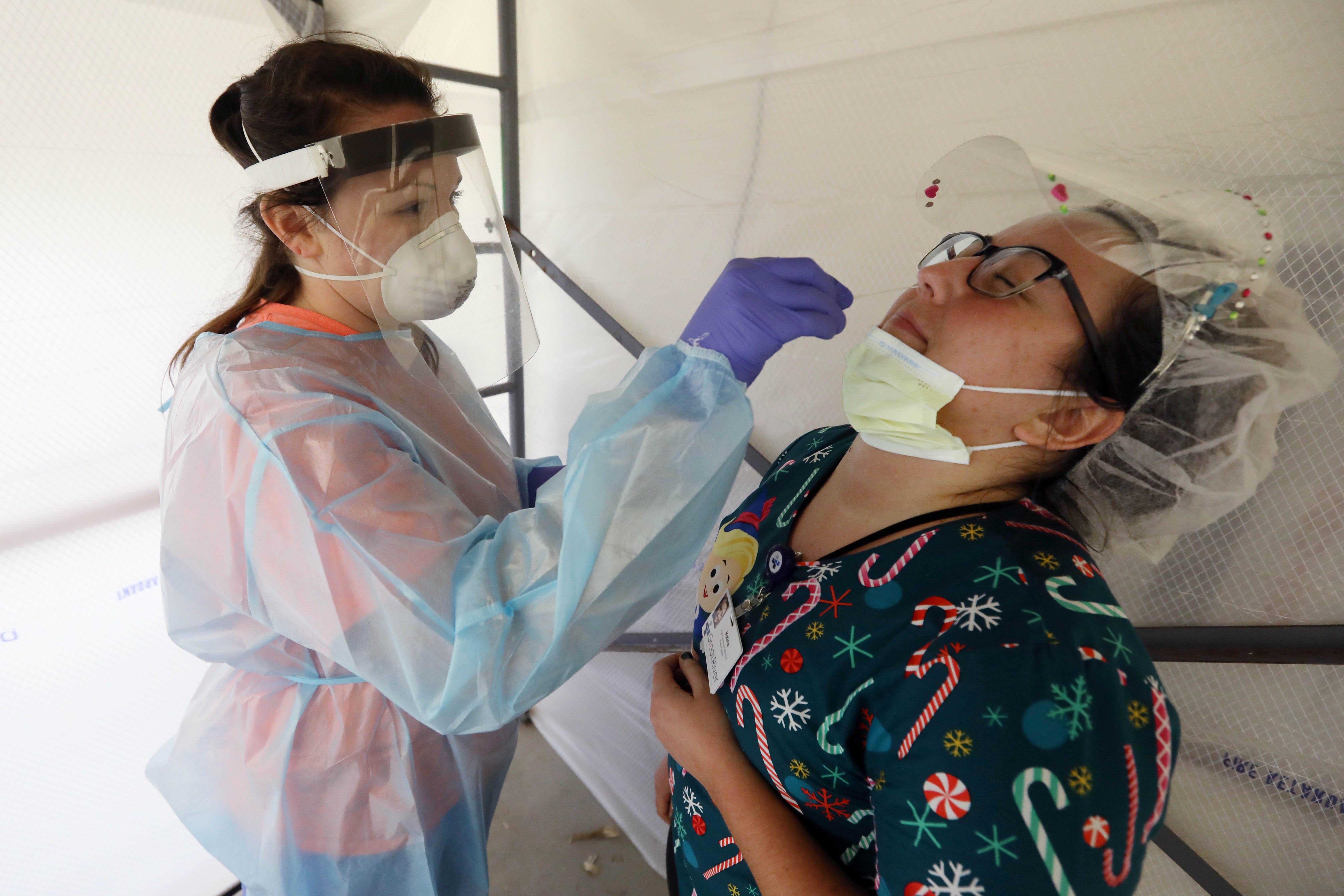 2:47 p.m. In a negative air flow room, Kalee Mitchell, a certified nursing assistant at the Great River Klein Center, ends her shift by taking a COVID-19 test administered by Sarah Day, a registered nurse from Great River Medical Center surgical services, Tuesday, Dec. 8, 2020, in the garage of the Klein Center. 
The Klein Center began testing employees and residents weekly in late August. One week later, testing was increase to twice per week for employees because of the increasing positivity rate in the community. 
Mitchell, who will embark on Southeastern Community College's nursing program in May, is balancing working full-time at the Klein Center Ñ plus mandatory overtime Ñ with taking several online prerequisite classes.
