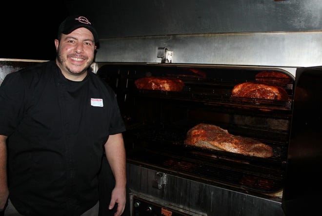 Chef Josh Freda, of Davis BBQ, shows off his smoker, filled with meat for the restaurant.