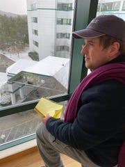 Travis Luxenberg, 33, looks out the window at Dartmouth Hitchcock Medical Center, where he stayed for several months over the spring and summer of 2020.