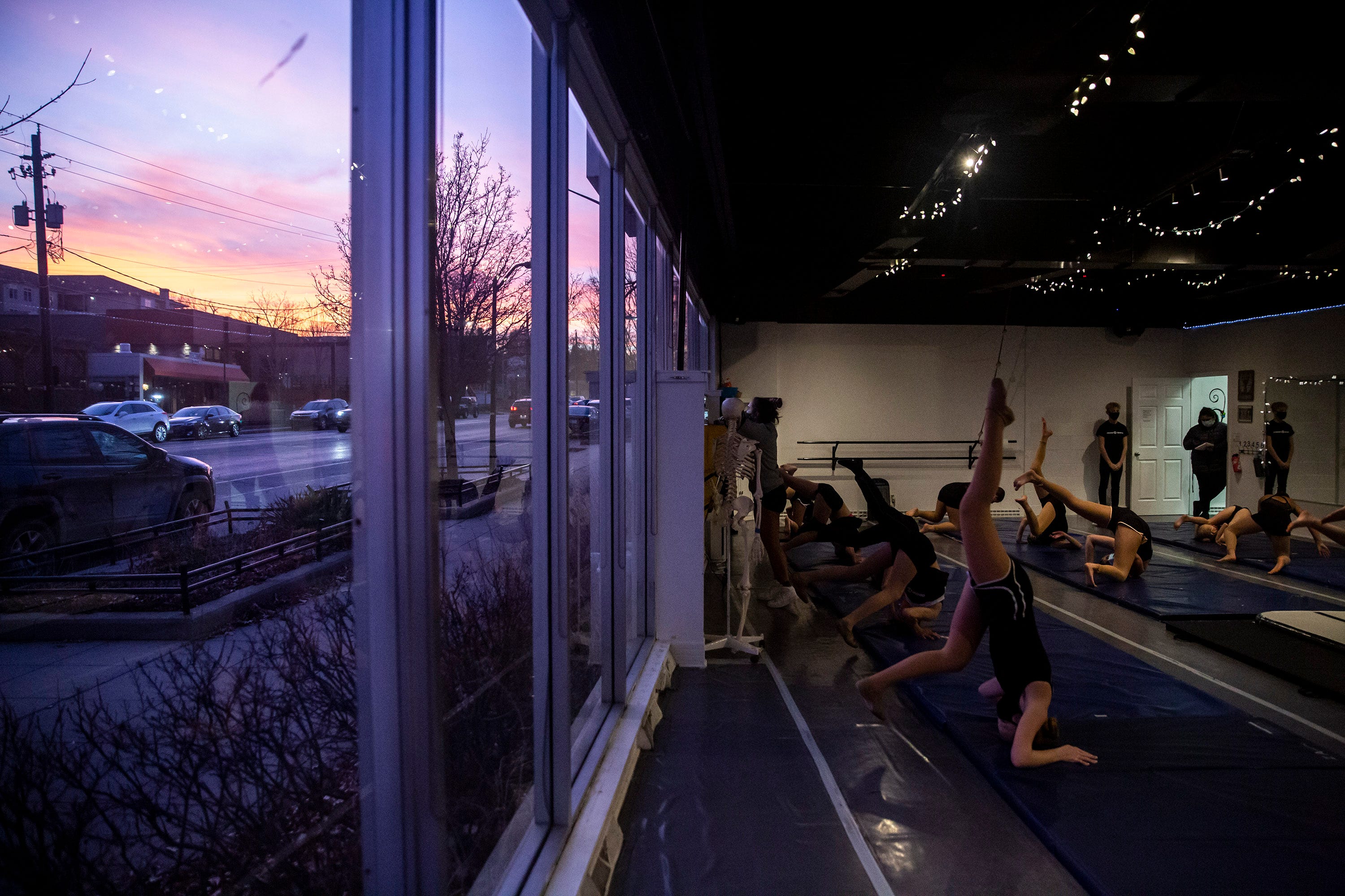 Studnets in Kelli Devine-Woods' tumbling class work through their technique on Tuesday, Dec. 8, 2020, inside the Devine Dancers' studio on Ingersoll Avenue in Des Moines. Each dance student is expected to wear a mask and practice from their assigned spot on the mats to keep their distance from classmates.