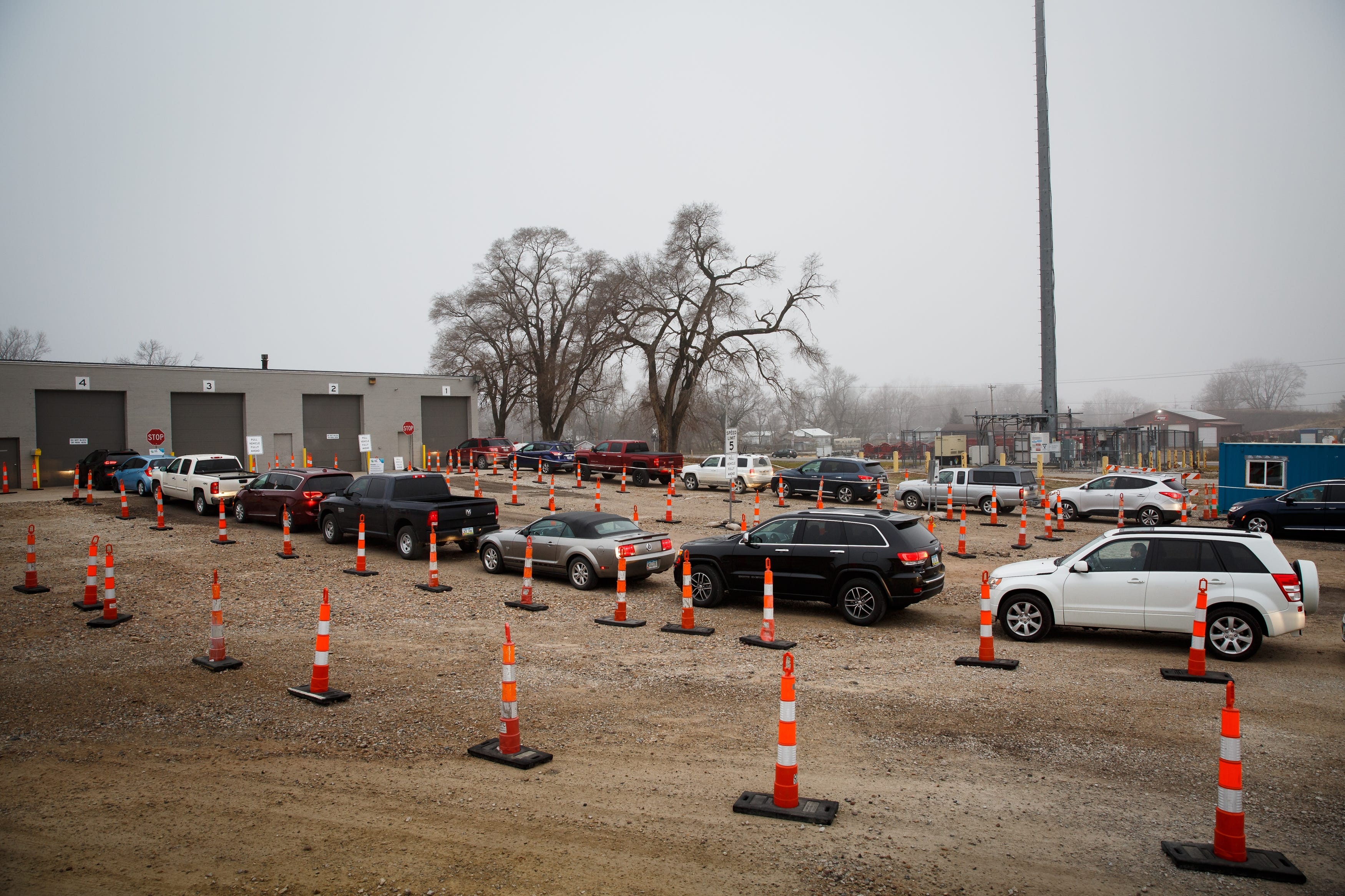 7:53 a.m. DES MOINES- Fog blankets a line of cars waiting for the garage doors to open to the Test Iowa site in Des Moines on Tuesday, Dec. 8, 2020. As cases of COVID-19 spike around the country, lines at the testing sites can stretch out of the pot hole laden gravel lot and onto the road. Extra lanes have been set up to get as many cars into the lot as possible, avoiding backups on the road.
