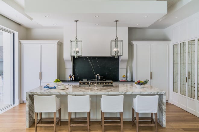 The kitchen features a beautiful plaster range hood complementing a full height soapstone splash, Lacanche stove and a show-stopping marble waterfall island.