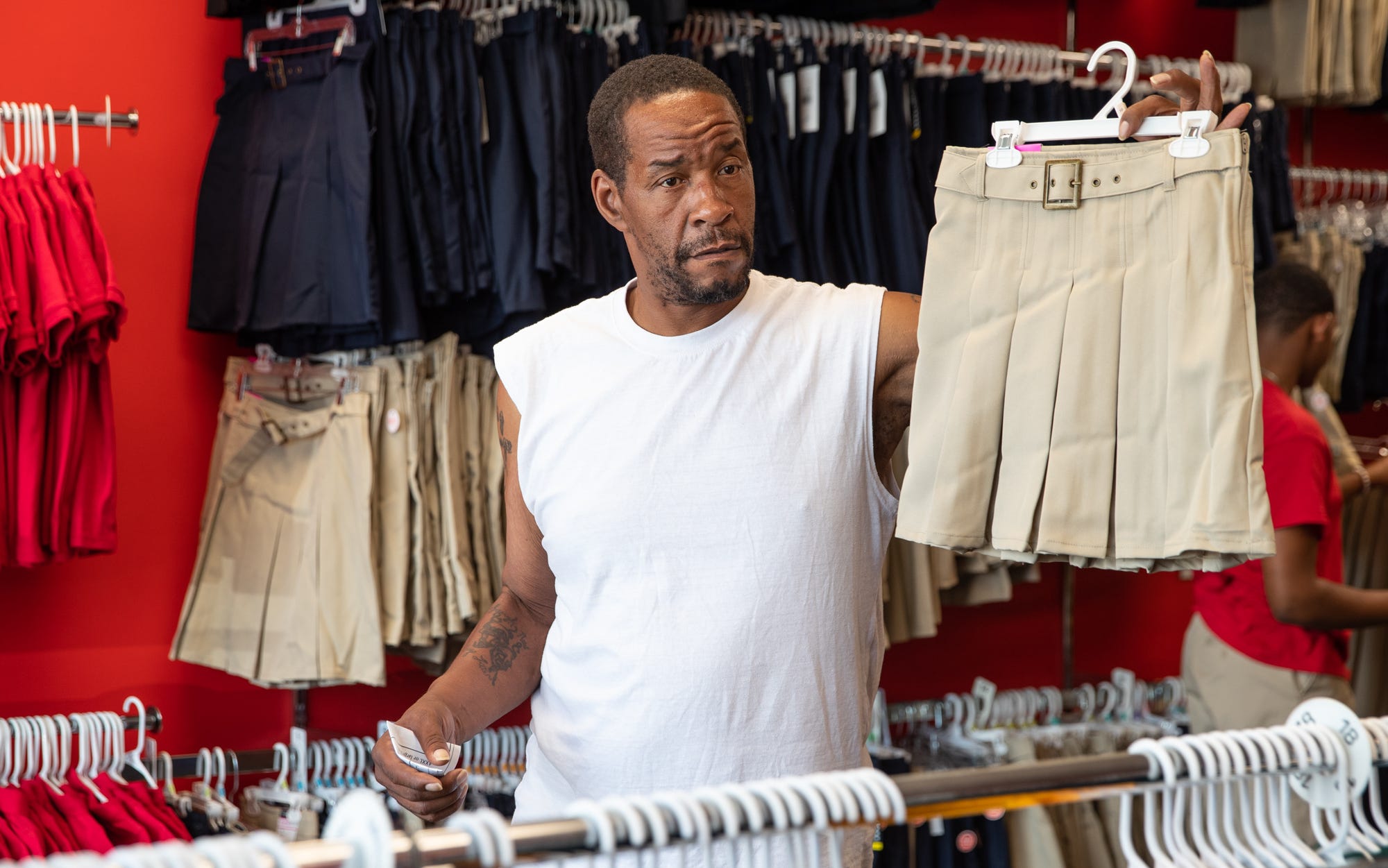 Kevin Rhodes Sr. holds up a skirt to get his daughter Ke'Asia's opinion while shopping for school uniforms at School Zone on Wednesday, July 24, 2019. "You like this one, momma?" he asked. "Or, you want a dark color?" Ke'Asia would pick the light color skirt. "I cook, clean, everything. I do the whole works," said Rhodes Sr. "It's kind of rough but I can handle it though." 