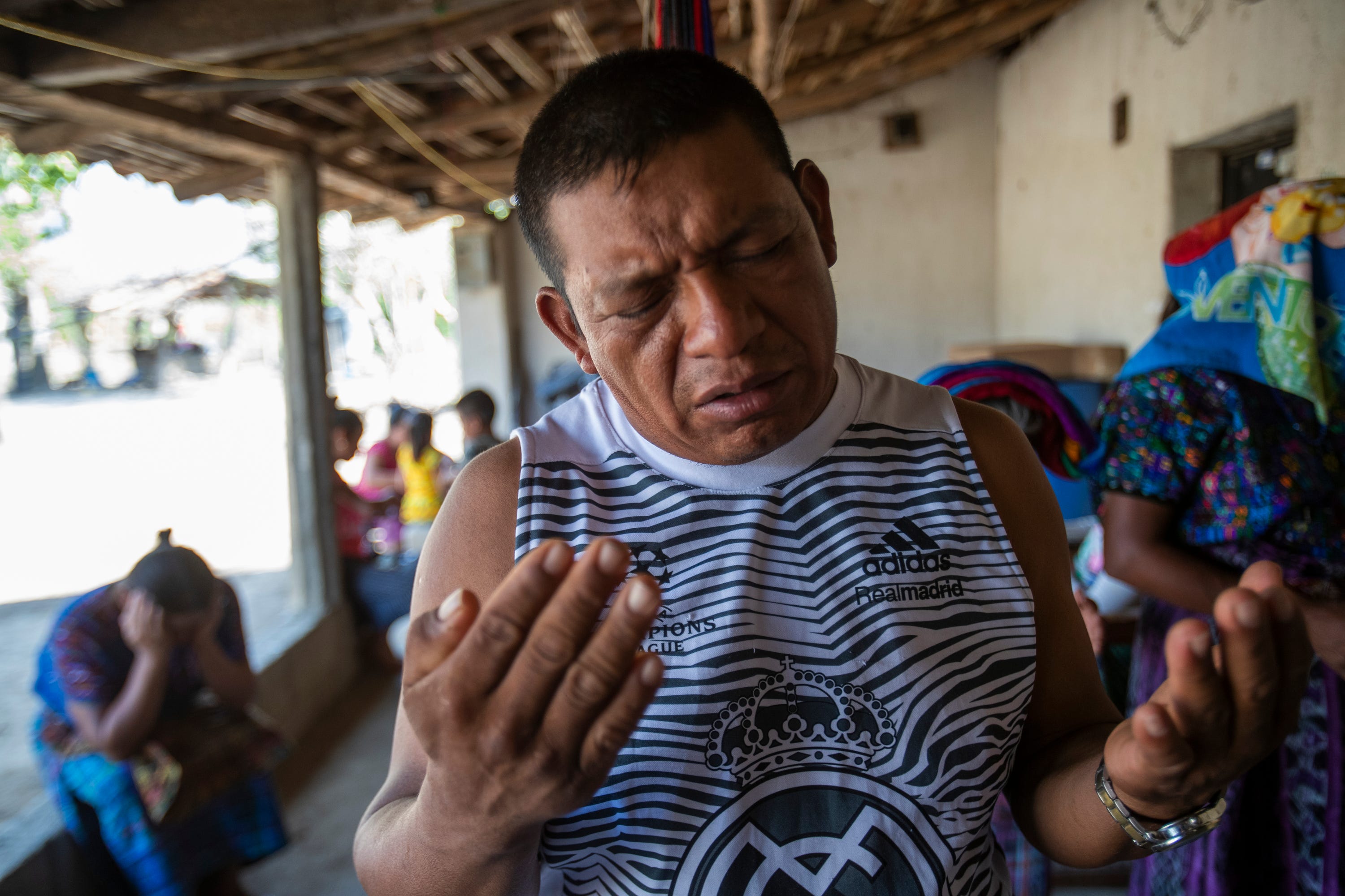 Francisco Sical prays for his father's health as members of his community gather for a moment of prayer in early March 2020.