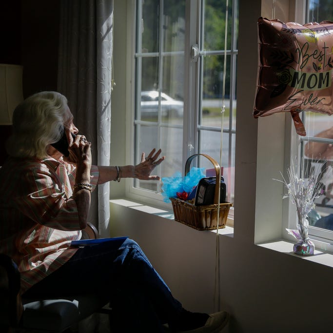 Mary Faye Cochran, 86, sings "You Are My Sunshine" over the phone to her son Stacey Smith through a window on Mother's Day, Sunday, May 10, 2020, at Provident Village at Creekside senior living in Smyrna, Ga. 