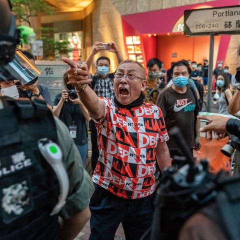 A pro-democracy supporter shouts at riot police du
