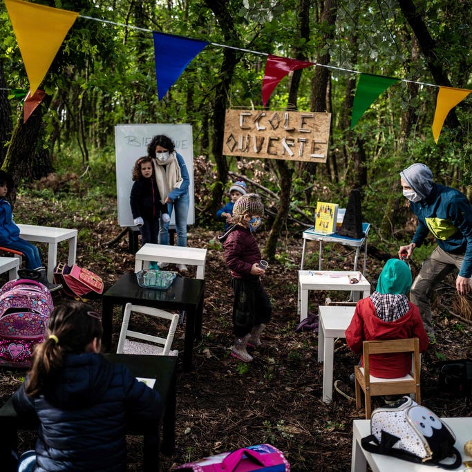 Children attend a course in the forest near Upie, France, on May 12, 2020. Some Drome pupils went to "school" again amongst oaks and pines with parents acting as teachers, to protest against the non-reopening of the school in the village.
