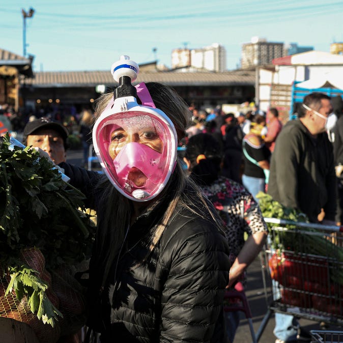 A shopper uses a snorkel mask as a precaution against the spread of the new coronavirus a she shops at La Vega market in Santiago, Chile, Thursday, April 2, 2020.