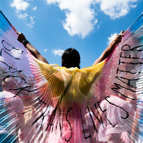 A protester displays wings while marching on on Ju