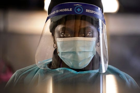 A tester wears personal protective equipment as she speaks to a patient at a mobile COVID-19 testing site on Tuesday in Auburn, Maine.