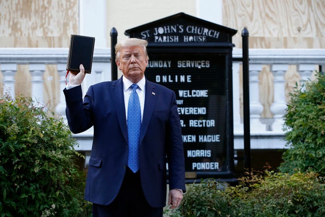 President Donald Trump holds a Bible in his hand as he visits from the White House in front of St. John's Church in Lafayette Park in Washington on Monday, June 1, 2020. 